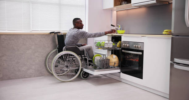 istock Young Man Sitting On Wheelchair Arranging Plates 1474486968
