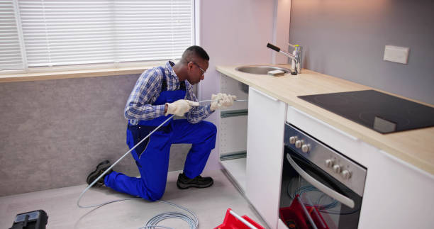 istock Young Male Plumber Cleaning Clogged Sink Pipe 1474487078