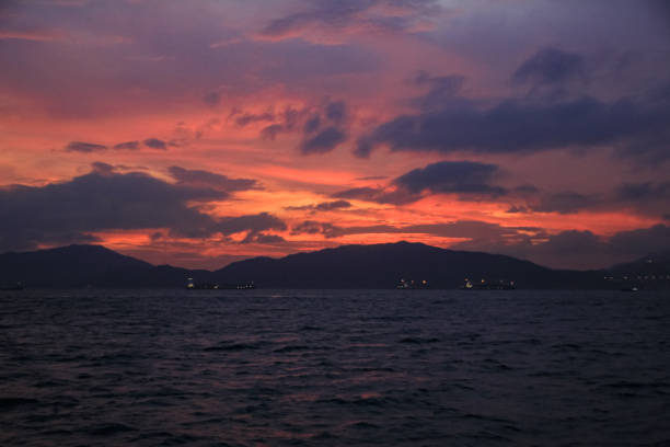 Calm seascape with sunset scene, red and orange sky with container ships. Stunning natural scene.