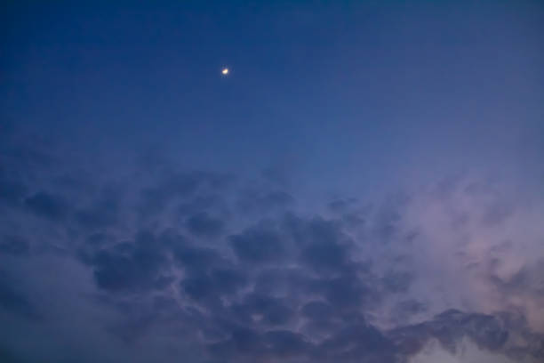 istock Low angle view of the sky with the shiny moon at dawn. 1474489738