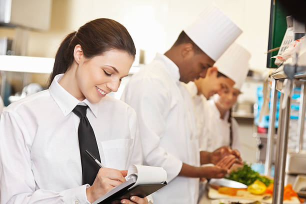 istock Restaurant waitress writing on order book in a commercial kitchen 147449296