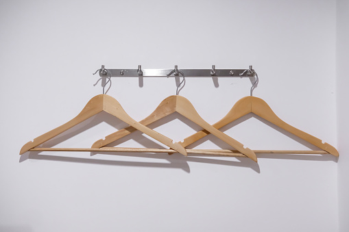 Wooden hangers on the white plain wall