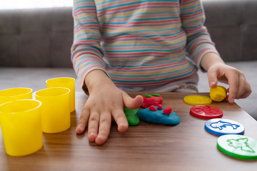 Cute girl making clay at home.