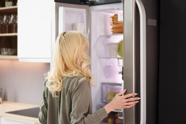 istock Young Woman Looking In Fridge 1474498400