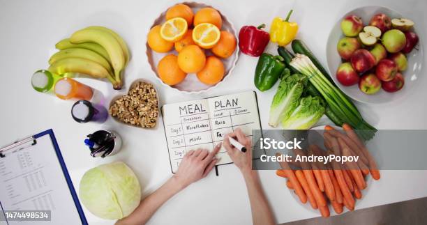 Female Dietitian Doctor Writing Meal Plan Stock Photo - Download Image Now - Healthy Eating, Fruit, Vegetable