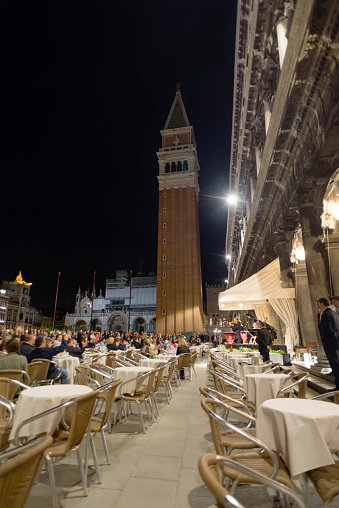 People listening to a small orchestra at an evening concert at the cafe 'Caffe Florian' on the St. Marks square in Venice