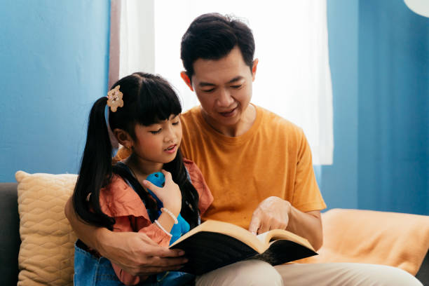 istock Father and daughter reading book together 1474500573