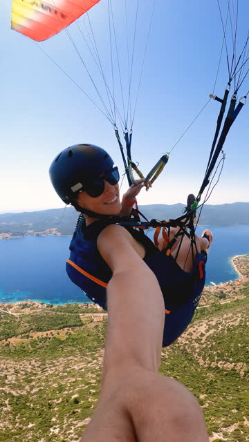 Young female enjoying freedom while paragliding