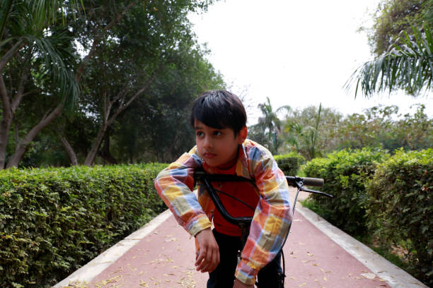 자전거 타기를 즐기는 인도 어린 소년. - clothing india delhi tired 뉴스 사진 이미지