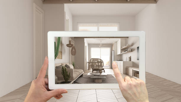 istock Augmented reality concept. Hand holding tablet with AR application used to simulate furniture and design products in empty interior with parquet, modern kitchen, living, dining room 1474516509
