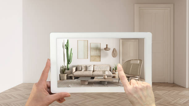 istock Augmented reality concept. Hand holding tablet with AR application used to simulate furniture and design products in empty interior with parquet, modern living room with sofa 1474516512
