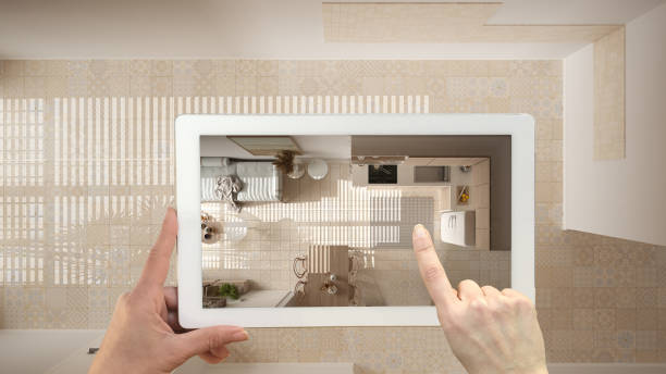 istock Augmented reality concept. Hand holding tablet with AR application used to simulate furniture and design products in empty interior with ceramics. Living room, top view, plan, above 1474516527