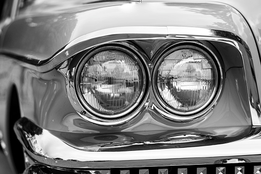 Detail of a vintage car. Close up of headlight retro classic car. Black and white photography. Classic car.