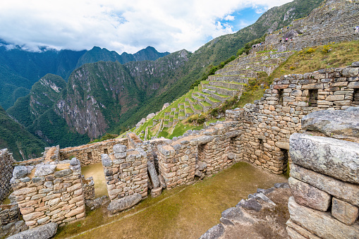 Machu Picchu, Aguas Calientes, Peru - March 19, 2023; Machu Picchu is a 15th-century Inca citadel located in the Eastern Cordillera of southern Peru on a 2,430-meter (7,970 ft) mountain ridge. It is located in the Machupicchu District within Urubamba Province  above the Sacred Valley, which is 80 kilometers (50 mi) northwest of Cusco. The Urubamba River flows past it, cutting through the Cordillera and creating a canyon with a tropical mountain climate.\n\nMost recent archaeologists believe that Machu Picchu was constructed as an estate for the Inca emperor Pachacuti (1438–1472). Often referred to as the \