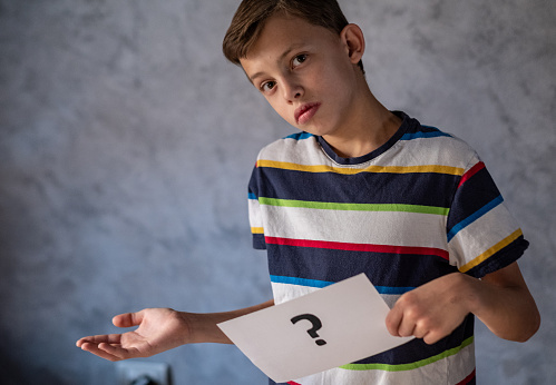 the boy asks a question and hold a paper with questionnaire
