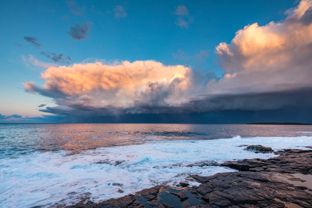 istock Dramatic storm over the ocean with waves crashing on rocks 1474525516