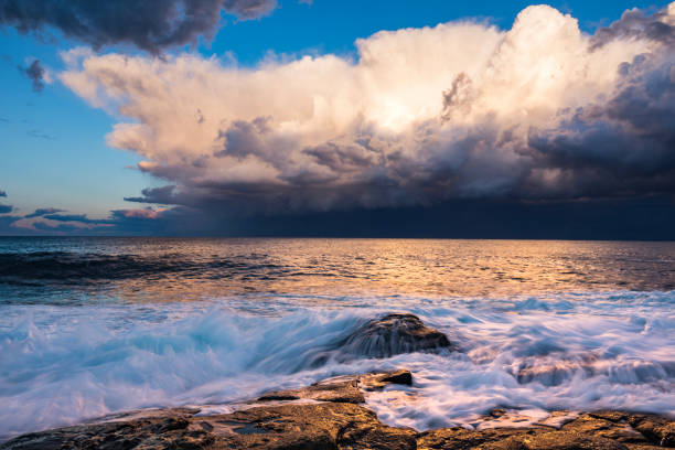 istock Dramatic storm over the ocean with waves crashing on rocks 1474525546