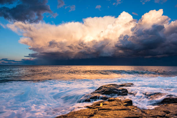 istock Dramatic storm over the ocean with waves crashing on rocks 1474525568