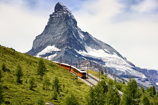 Train of Jungfraubahn running towards Jungfraujoch under the famous peak Jungfrau near the station Eigergletscher on bernese Oberland, Switzerland.