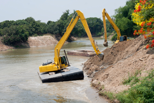 excavator machine group works on floating platform at river for protect flood