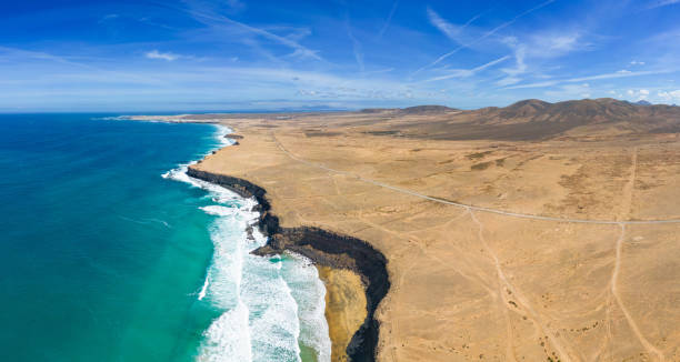 vue panoramique aérienne de haut niveau sur les falaises rocheuses et les plages avec la montagne volcanique en toile de fond près d’el cotillo à fuerteventura en espagne - cotillo fuerteventura spain tourism photos et images de collection