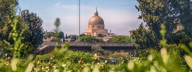 Idillic view of the Church of Santi Pietro e Paolo, framed by plants and trees in EUR district in Rome, Italy