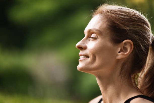 istock Peaceful young lady smiling with closed eyes while meditating 1474555042