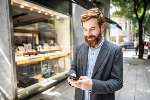 istock Businessman using smartphone outdoors 1474557694