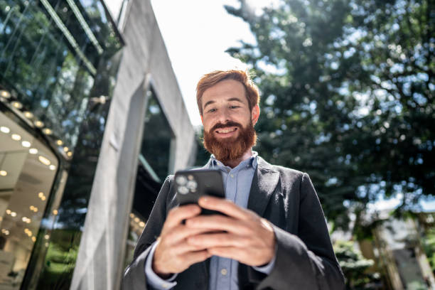istock Businessman using smartphone outdoors 1474557712