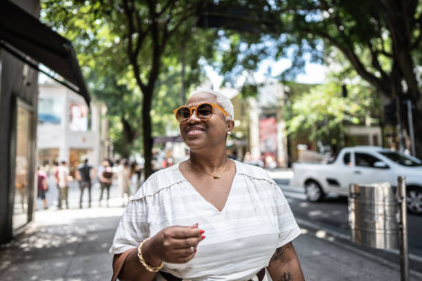 mature woman shopping and walking in the city - women common 40s candid imagens e fotografias de stock