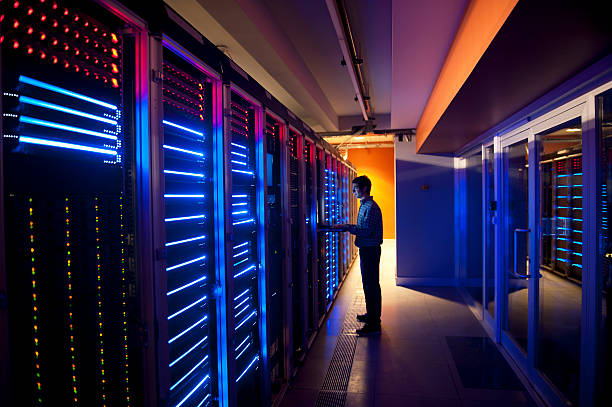 IT Engineer in Action Configuring Servers Modern interior of server room in datacenter. IT Engineer in Action Configuring Servers telecommunications equipment stock pictures, royalty-free photos & images