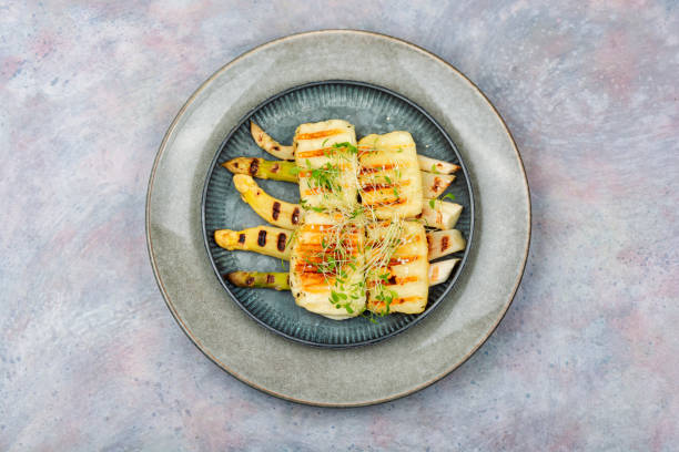 Baked white asparagus with halloumi cheese. stock photo