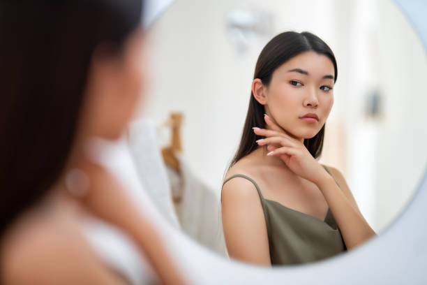 istock woman looking at mirror 1474564451