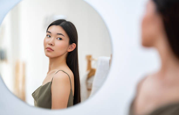 istock woman looking at mirror 1474564473