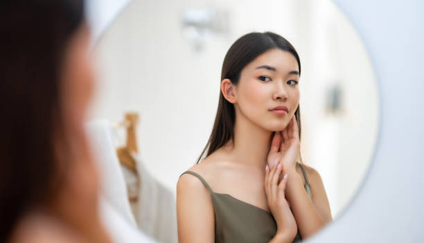 istock woman looking at mirror 1474564475