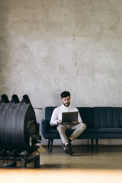 istock The handsome man working on the laptop on the sofa 1474569686