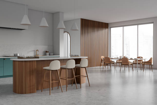 istock Corner view on bright kitchen room interior with island, table 1474569859