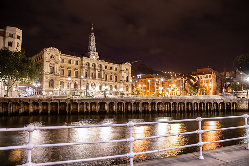 Famous building in Bilbao 19th century City Hall at night Nervion River light reflections Basque Country Northern Spain Europe