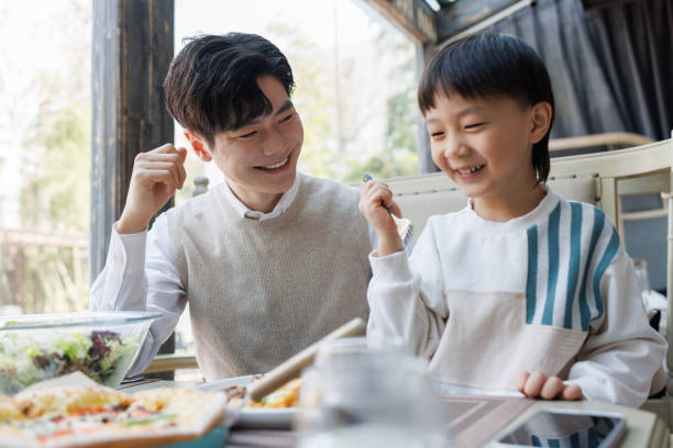 istock Young father and son have lunch in a restaurant 1474578857