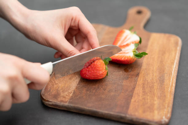 istock slicing a strawberry on a cutting board 1474584209
