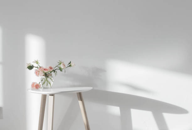 istock pink roses in glass jar on white modern table on background white wall 1474589306