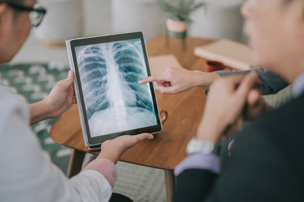 Asian doctors looking at xray image on digital tablet discussion in doctor's office