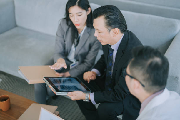 istock Asian doctors looking at xray image on digital tablet discussion in doctor's office 1474591083