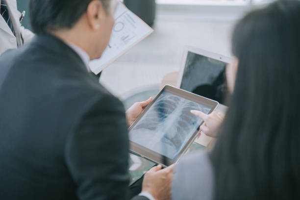 Asian doctors looking at xray image on digital tablet discussion in doctor's office