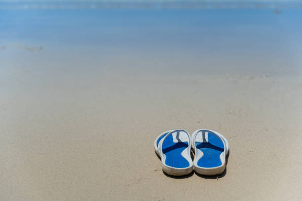 Flip Flops on a sandy ocean beach - Summer vacation concept.