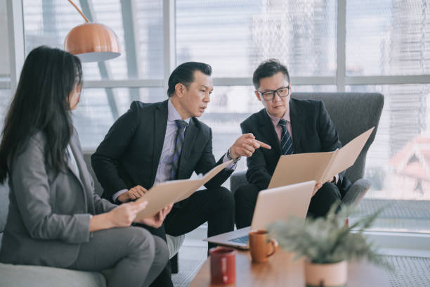 istock Asian senior management asking question on the document presented by his coworker in office 1474591779
