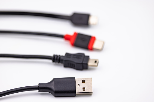 Mini USB connector and cable alongside other USB type adapters isolated in studio against white background