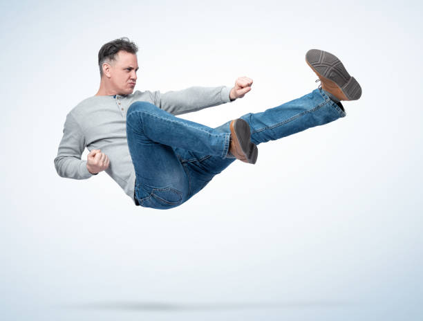 istock Man in casual clothes make karate fight jump, on light background. 1474593663