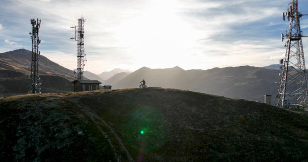 istock E-mountain biker on hill below transmission tower 1474600245