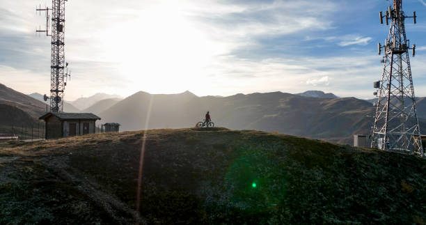istock E-mountain biker on hill below transmission tower 1474600260